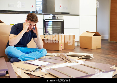 Frustrato uomo mettendo insieme Self Montaggio dei mobili Foto Stock