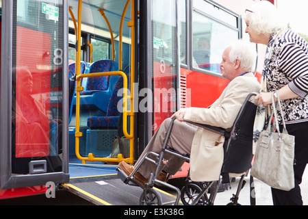 Coppia senior Autobus con rampa di accesso per sedia a rotelle Foto Stock