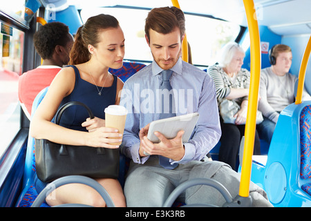 Imprenditore e la donna con tavoletta digitale sul bus Foto Stock