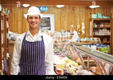 Maschio assistente alle vendite in negozio di specialità gastronomiche Foto Stock