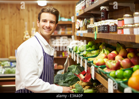 Maschio assistente alle vendite al contatore di vegetali di Farm Shop Foto Stock