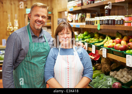 Due assistente vendite al contatore di vegetali di Farm Shop Foto Stock