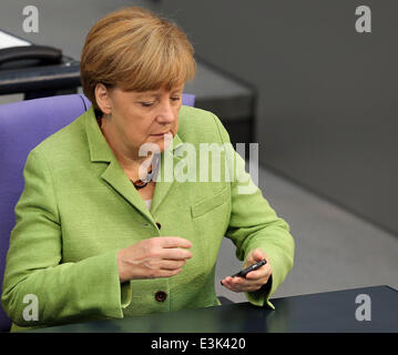 Berlino, Germania. Il 24 giugno 2014. Il cancelliere tedesco Angela Merkel (CDU) guarda al suo telefono cellulare durante un dibattito al Bundestag a Berlino, Germania, 24 giugno 2014. Foto: WOLFGANG KUMM/DPA/Alamy Live News Foto Stock