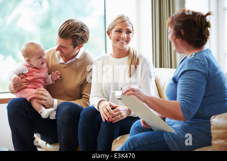 Visitatore di salute parlando di famiglia con bambino piccolo Foto Stock