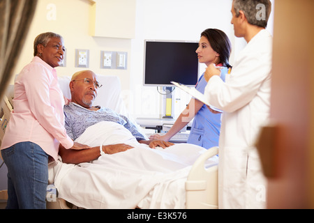 Il team medico di incontro con coppia Senior nella stanza di ospedale Foto Stock