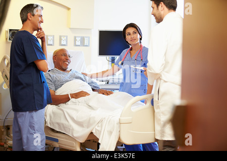 Il team medico di incontro con il Senior l uomo nella stanza di ospedale Foto Stock