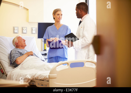 Il team medico di incontro con il Senior l uomo nella stanza di ospedale Foto Stock