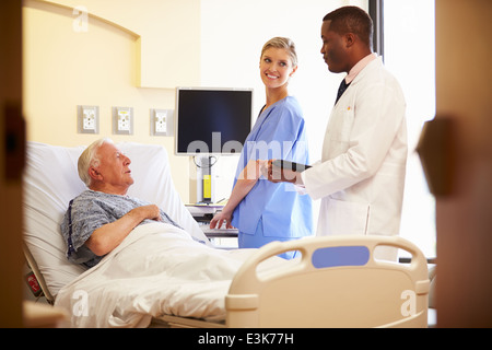 Il team medico di incontro con il Senior l uomo nella stanza di ospedale Foto Stock