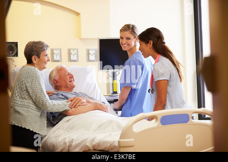 Il team medico di incontro con coppia Senior nella stanza di ospedale Foto Stock