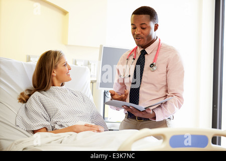 Medico di parlare al paziente di sesso femminile nella stanza di ospedale Foto Stock