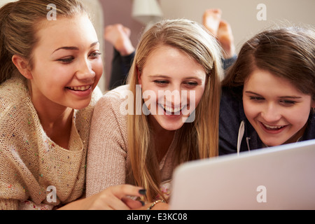 Tre ragazze adolescenti utilizzando computer portatile in camera da letto Foto Stock