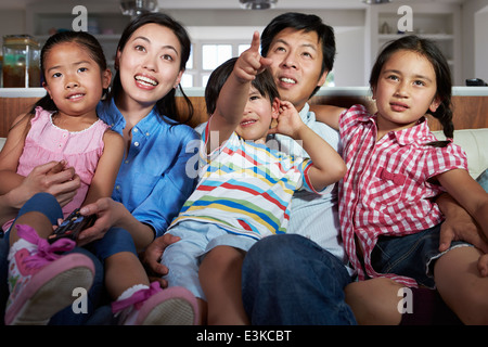 Famiglia asiatica seduto sul divano guardando la TV insieme Foto Stock