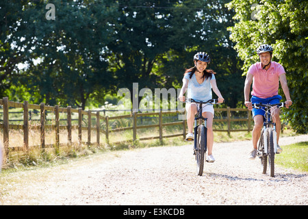 Coppia asiatica sul tragitto in bicicletta in campagna Foto Stock