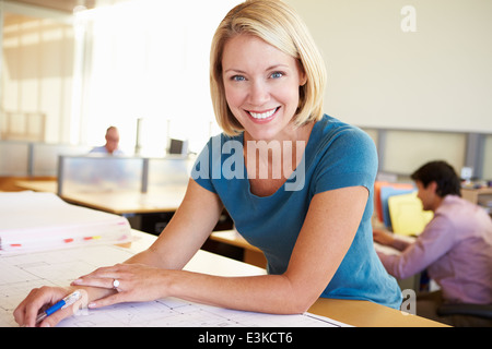Architetto femmina studiando piani in Office Foto Stock