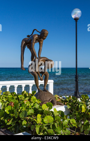 Sculture decorative lungo il Malecon con navi da crociera nel porto di Cozumel, Messico. Foto Stock