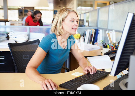 La donna lavora al computer in un ufficio moderno Foto Stock