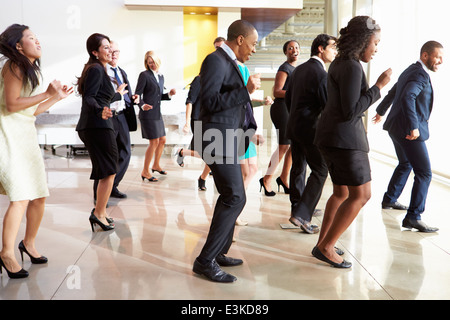 Imprenditori e imprenditrici Dancing in Office Lobby Foto Stock