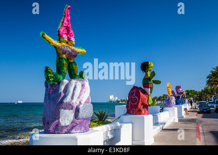 Sculture decorative lungo il Malecon con navi da crociera nel porto di Cozumel, Messico. Foto Stock