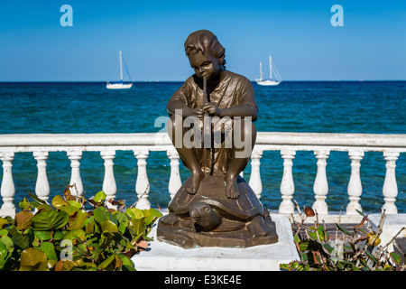 Sculture decorative lungo il Malecon con navi da crociera nel porto di Cozumel, Messico. Foto Stock