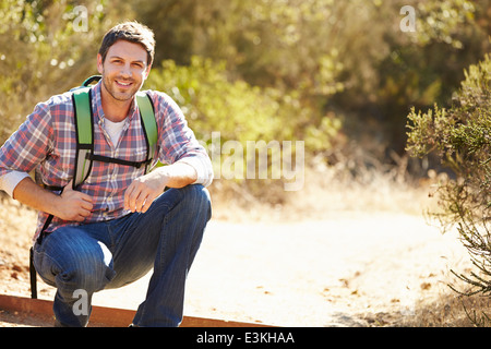 Ritratto di uomo escursioni in campagna indossando uno zaino Foto Stock