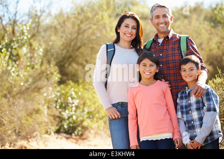 Ritratto di famiglia escursioni in campagna indossando zaini Foto Stock