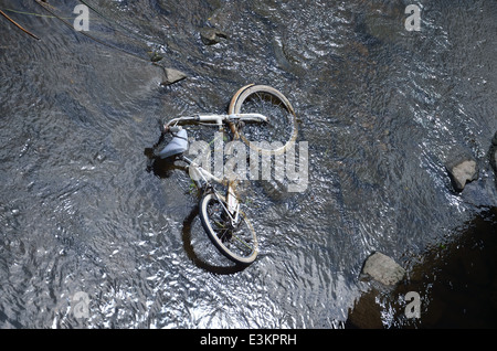 Oggetto di dumping di biciclette in un fiume Foto Stock