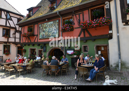 Persone mangiare fuori del ristorante medievale in Riquewihr regione Alsace Francia Foto Stock