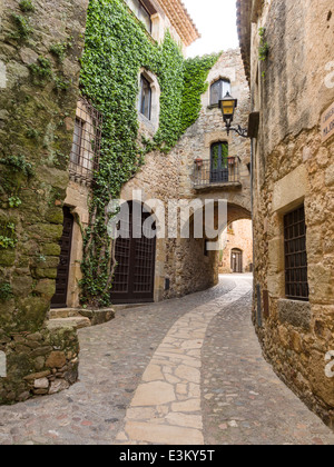 Avvolgimento Back Street in Pals. Un percorso curvo/street in Pals conduce ad un cortile privato. Ivy cresce in modo decorativo fino alle pareti Foto Stock