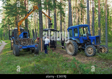 Rottura del trattore in legno. Il trattore arare un solco di divisione luoghi di foresta a firestorm. Foto Stock