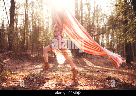 Immagine della giovane donna in esecuzione con coperta in foresta, Massachusetts, STATI UNITI D'AMERICA Foto Stock