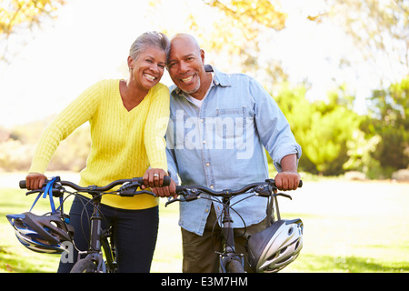 Coppia senior sul tragitto in bicicletta in campagna Foto Stock
