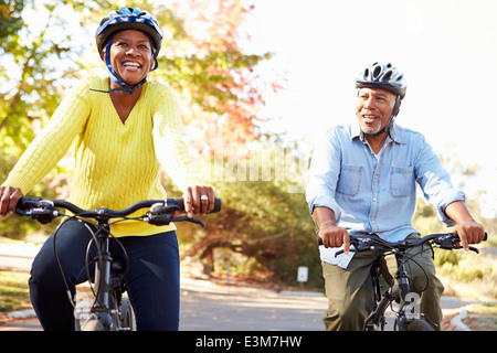 Coppia senior sul tragitto in bicicletta in campagna Foto Stock