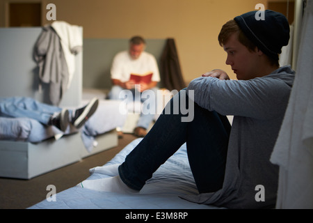 Gli uomini giacente su letti di ricovero per senzatetto Foto Stock