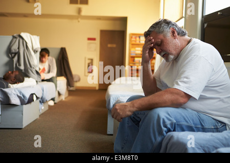 Gli uomini giacente su letti di ricovero per senzatetto Foto Stock