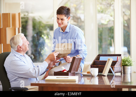 Nonno che mostra documento al nipote adolescente Foto Stock