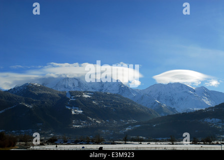 Il Mont Blanc su una soleggiata giornata invernale con nubi lenticolari al di sopra di due delle sue cime Foto Stock