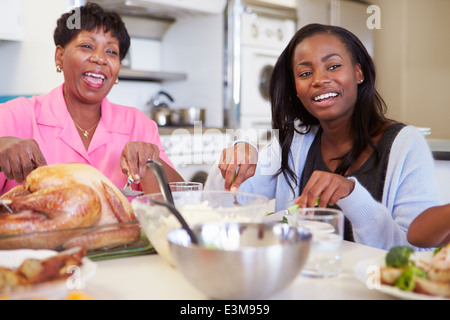 Madre e figlia adulta avente famiglia pasto a tavola Foto Stock