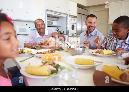 Famiglia Multi-Generation seduti a tavola a mangiare pasti Foto Stock