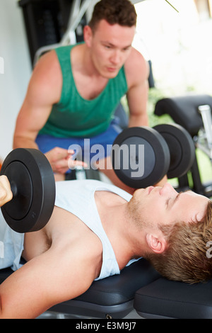 Due giovani uomini la formazione in palestra con pesi Foto Stock