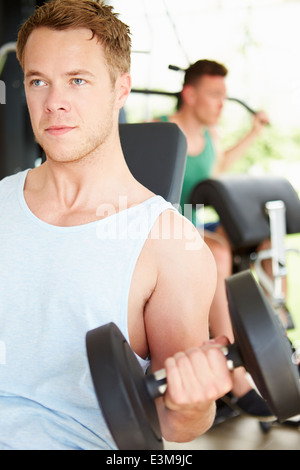 Due giovani uomini la formazione in palestra con pesi Foto Stock