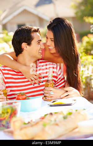 Coppia romantica gustando pasti all'aperto in giardino Foto Stock