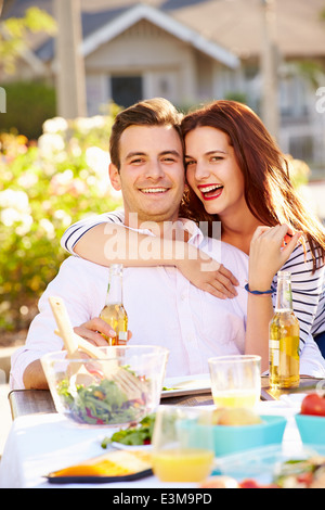 Coppia romantica gustando pasti all'aperto in giardino Foto Stock