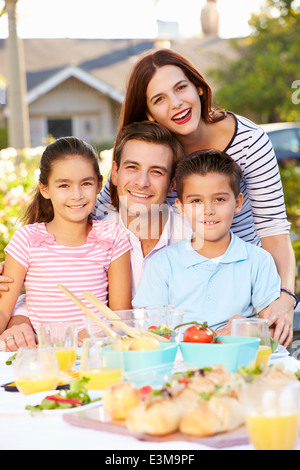 Godendo della famiglia pasto all'aperto in giardino Foto Stock