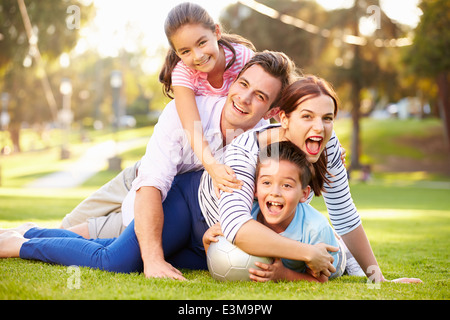 Famiglia giacente su erba in Park insieme Foto Stock