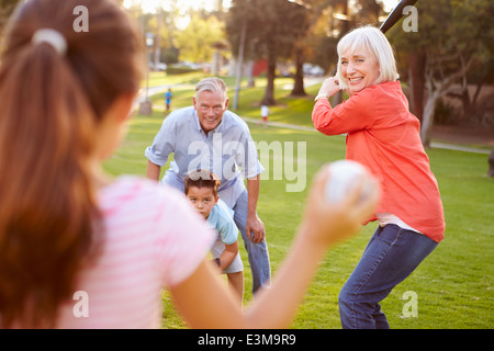 Nonni a giocare a baseball con i nipoti in posizione di parcheggio Foto Stock