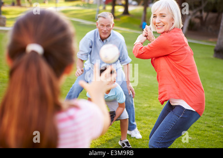 Nonni a giocare a baseball con i nipoti in posizione di parcheggio Foto Stock