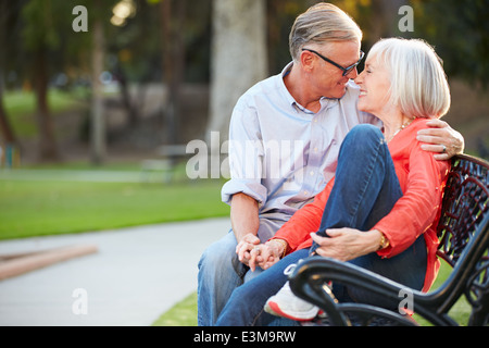 Coppia coppia romantica seduto su una panchina nel parco insieme Foto Stock