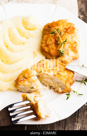 Cotolette di pollo e purè di patate in una piastra da vicino Foto Stock