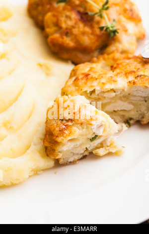 Cotolette di pollo e purè di patate in una piastra da vicino Foto Stock