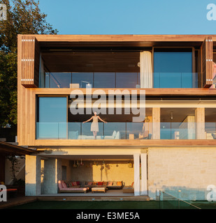 Donna in piedi sul balcone di lusso Foto Stock